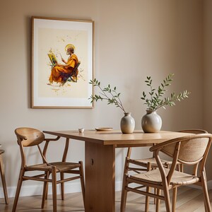 May include: A framed wall art print featuring a bearded figure in orange robes painting on a canvas, displayed above a wooden dining table with two ceramic vases containing green branches and three wooden chairs with woven seats.