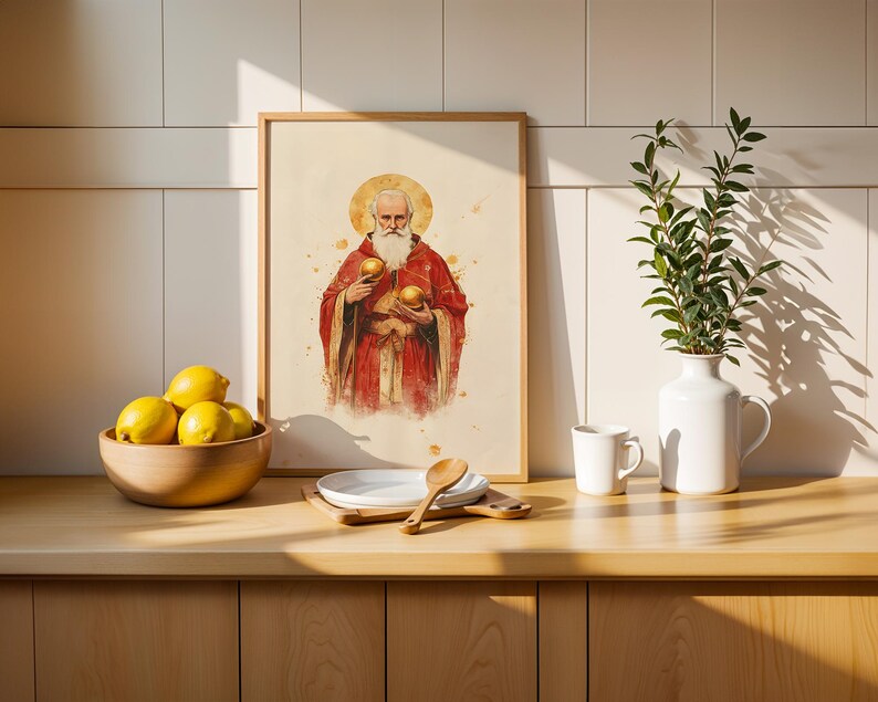 May include: A framed wall art print featuring a watercolour illustration of a bearded figure in red robes with a golden halo, holding two golden spheres. The artwork is displayed in a light wood frame with a cream-coloured background and paint splatters.