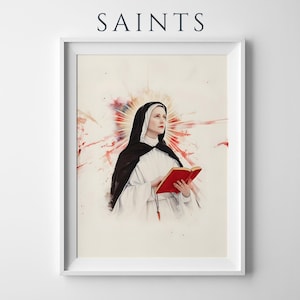 May include: A framed art print titled SAINTS featuring a watercolor-style illustration of a person in a white and black habit holding a red book. The figure has a glowing halo effect behind their head with red and orange paint splatters.