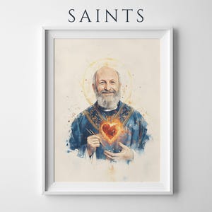 以下が含まれることがあります： SAINTSと題された額入りアートプリント。青い祭服を着て、胸に燃えるような輝くハートのエンブレムと金色の光輪を身につけた髭のある人物の水彩画風の肖像画が、シンプルな白い長方形のフレームに収められています。