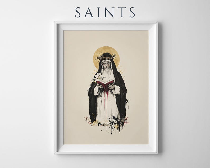 May include: A framed art print titled SAINTS featuring a black and white illustration of a figure in a dark habit and white veil, wearing a crown of thorns, holding a red book and a white lily, with a gold halo and red paint splatters.