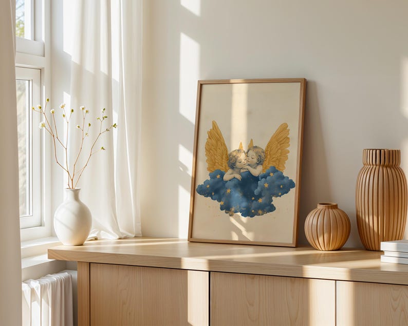 May include: A framed rectangular wall art print featuring two cherubs with large golden wings resting on a dark blue cloud filled with small yellow stars. The illustration is set against a cream-coloured background within a light wood frame.