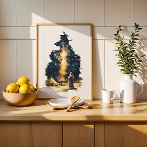 May include: A framed rectangular wall art print featuring a dark blue and gold celestial night sky scene with a figure standing near a tent in a desert landscape. The artwork is displayed on a wooden counter next to a bowl of yellow lemons.