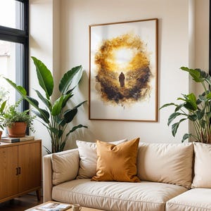 K&ouml;nnte beinhalten: Ein gerahmter Wandkunstdruck mit einer Illustration im Aquarellstil, die eine einsame Figur zeigt, die auf ein helles, leuchtendes goldenes Licht zugeht, umgeben von dunklen, strukturierten abstrakten Pinselstrichen in Braun- und Ockert&ouml;nen.