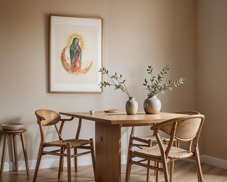 May include: A framed wall art print depicting a figure in a teal cloak and red dress standing on a crescent moon with a golden halo, displayed above a wooden dining table with four chairs and two ceramic vases containing green leafy branches.