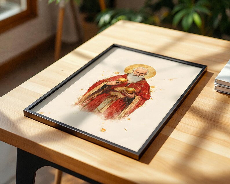 May include: A framed print featuring a watercolour-style illustration of a bearded figure with a golden halo, wearing a red robe and holding two golden spheres. The artwork is set against a cream-coloured background with subtle gold paint splatters.
