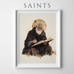 Pode incluir: Uma impress&atilde;o de arte emoldurada intitulada SAINTS apresentando uma ilustra&ccedil;&atilde;o de uma figura barbuda com um manto castanho escuro com capuz escrevendo num livro aberto. A figura tem uma aur&eacute;ola dourada atr&aacute;s da cabe&ccedil;a num fundo creme.