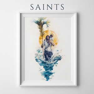 Puede incluir: Una impresi&oacute;n en acuarela enmarcada titulada SAINTS que muestra a una figura cargando a un ni&ntilde;o sobre sus hombros mientras camina por agua azul. La figura sostiene una hoja de palma alta, con un gran c&iacute;rculo solar amarillo y salpicaduras.