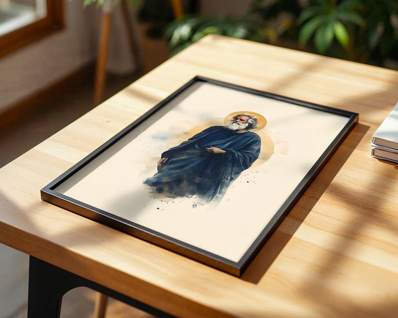 May include: A framed art print featuring a watercolor-style illustration of a bearded figure with long hair wearing a dark blue robe. The figure is depicted with a golden circular halo behind the head against a cream-colored background.