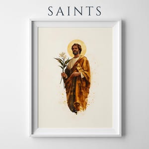 K&ouml;nnte beinhalten: Ein gerahmter Kunstdruck mit dem Titel SAINTS, der eine Aquarell-Illustration einer b&auml;rtigen Figur in einem goldbraunen Gewand zeigt, die eine wei&szlig;e Lilie h&auml;lt. Die Figur hat einen kreisf&ouml;rmigen goldenen Heiligenschein vor einem cremefarbenen Hintergrund.