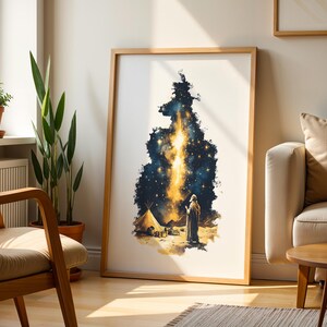 May include: A framed vertical wall art print featuring a dark blue and gold celestial scene. The illustration depicts a figure standing in a desert landscape near a tent, looking up at a bright, glowing vertical beam of light amidst starry skies.