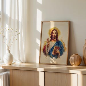 May include: A framed watercolor-style print depicting a figure with long brown hair and a beard, wearing a white robe and blue mantle, holding a book in one hand and raising the other in a gesture of blessing, set against a golden halo.