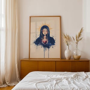 K&ouml;nnte beinhalten: Ein gerahmter Wandkunstdruck mit einer Illustration im Aquarellstil einer Figur mit geschlossenen Augen, die einen dunkelblauen Kapuzenumhang tr&auml;gt, mit einem leuchtenden goldenen Heiligenschein und einem leuchtend roten Herzen auf der Brust.