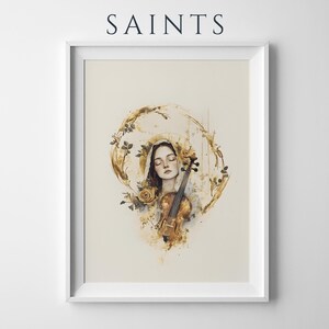 Op de afbeelding: Een ingelijste kunstdruk getiteld SAINTS met een aquarelillustratie van een persoon met gesloten ogen, een hoofdbedekking dragend, een viool vasthoudend, omringd door gouden bloemaccenten en abstracte gouden verfstreken op een cr&egrave;mekleurige achtergrond.