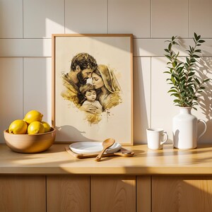 May include: A framed watercolor-style art print depicting a family of three in sepia tones, featuring a bearded figure, a person with a head covering, and a child. The artwork is displayed alongside a wooden bowl of yellow lemons and a white vase.