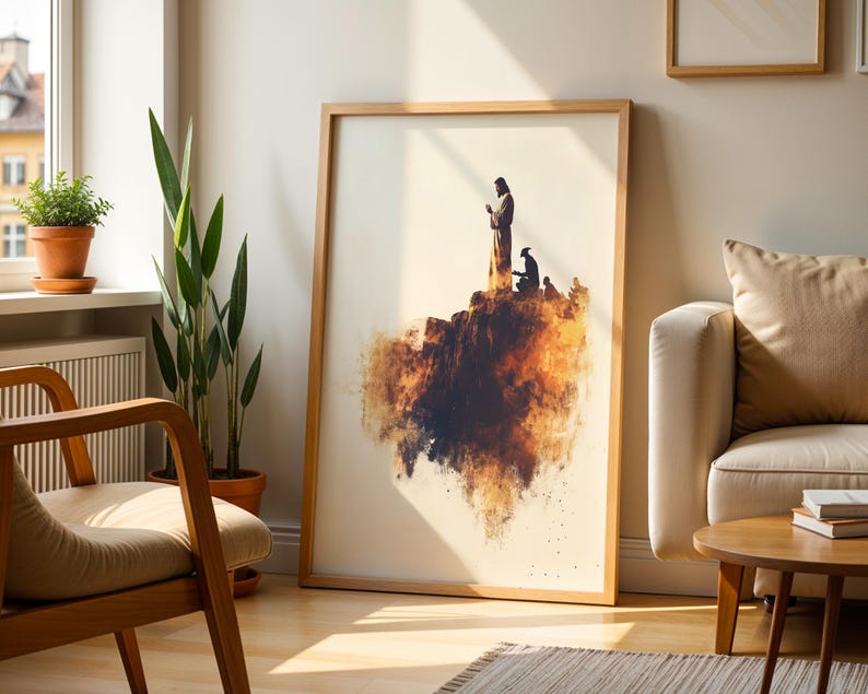 K&ouml;nnte beinhalten: Ein gerahmter Wandkunstdruck mit der Silhouette einer stehenden und einer knienden Figur auf einer felsigen Klippe, gestaltet in warmen orangefarbenen, braunen und schwarzen Aquarell-Spritzern auf cremefarbenem Hintergrund.
