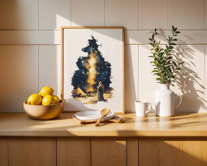 May include: A framed rectangular wall art print featuring a dark blue and gold celestial night sky scene with a figure standing near a tent in a desert landscape. The artwork is displayed on a wooden counter next to a bowl of yellow lemons.