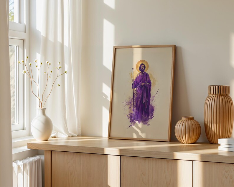 May include: A framed wall art print featuring a watercolor-style illustration of a bearded figure in a purple robe holding a staff, with a golden halo behind the head, set against a light beige background within a simple wooden frame.