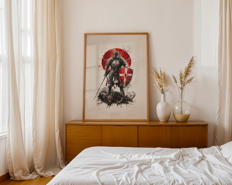 May include: A framed wall art print featuring a knight in full armour holding a sword and a shield with a red cross, standing over a dark creature. The artwork is set against a large red circular background with black ink splatter accents.