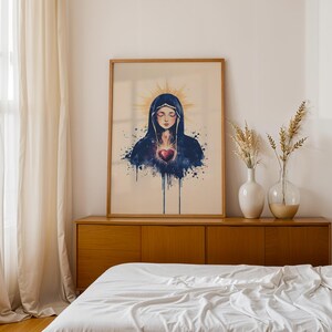 May include: A framed wall art print featuring a watercolor-style illustration of a figure with closed eyes, wearing a dark blue hooded cloak. A glowing golden halo surrounds the head, and a vibrant red heart is centered on the chest area.