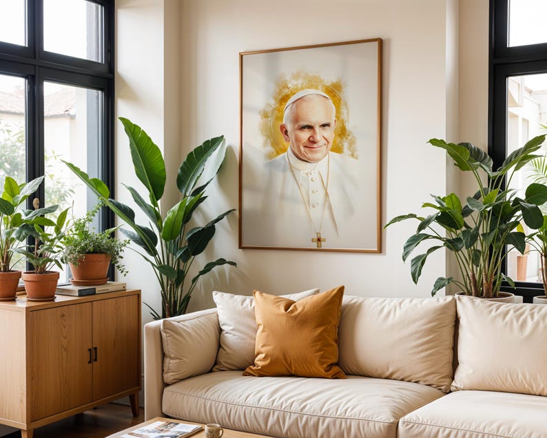 Pu&ograve; includere: Un ritratto incorniciato di Papa Giovanni Paolo II con un effetto alone dorato in stile acquerello dietro la testa. Il soggetto indossa una talare bianca e una croce pettorale d'oro. L'opera &egrave; esposta su una parete sopra un divano beige.