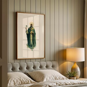 May include: A framed wall art print featuring a watercolour-style illustration of a bearded figure wearing a crown and a long dark green robe, holding a shamrock in one hand and a staff in the other, set against a light cream background.