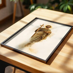 Peut inclure: Une impression encadr&eacute;e repr&eacute;sentant une figure barbue en robes fluides tenant une croix en bois et une miche de pain. L'illustration utilise des tons beige et marron doux avec un halo dor&eacute; autour de la t&ecirc;te sur un fond cr&egrave;me clair.