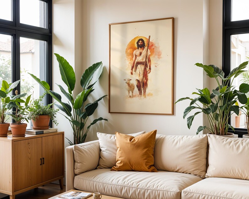 May include: A framed wall art print featuring a watercolor illustration of a bearded figure with long hair, wearing a simple tunic and holding a wooden staff, accompanied by a small lamb, set against a circular orange sun-like background.