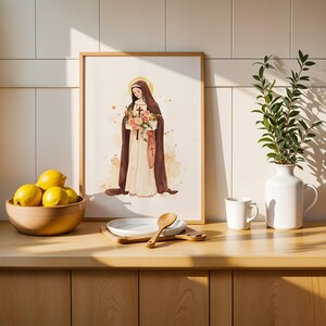 Peut inclure: Une impression encadr&eacute;e de style aquarelle repr&eacute;sentant une silhouette en habit marron tenant un bouquet de fleurs roses et blanches, plac&eacute;e &agrave; c&ocirc;t&eacute; d'un bol en bois de citrons jaunes, d'une assiette blanche avec une cuill&egrave;re en bois, un mug et un vase.