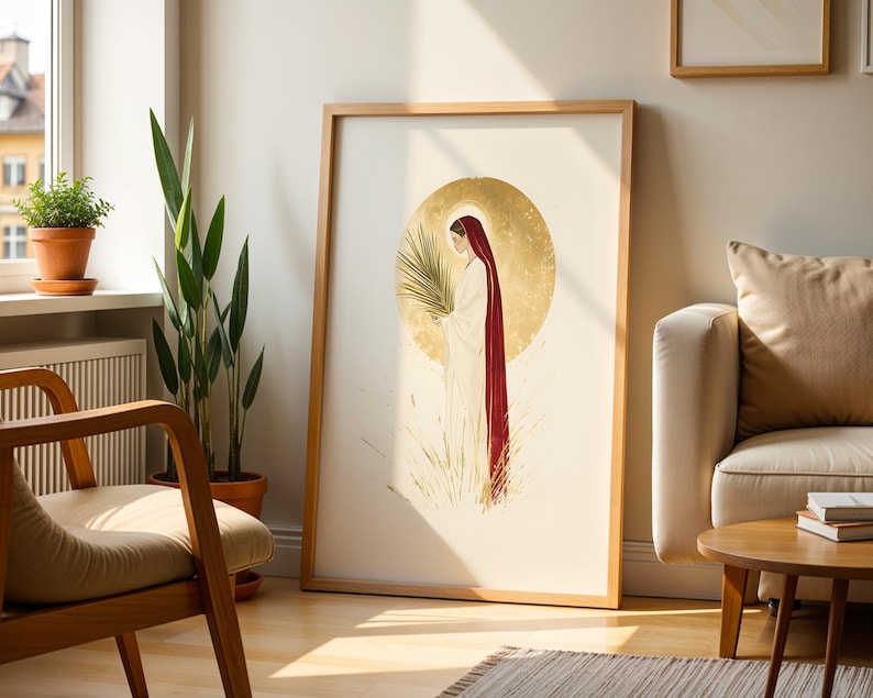 Puede incluir: Una l&aacute;mina de arte enmarcada con una ilustraci&oacute;n estilizada de una figura con t&uacute;nica blanca y una larga capa roja, sosteniendo una palma. La figura est&aacute; centrada sobre un gran halo circular dorado y texturizado con hierba dorada.