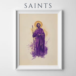 May include: A framed art print titled SAINTS featuring a bearded figure in a purple robe holding a wooden staff. The figure has a golden halo against a cream background with purple watercolor-style splashes at the base of the illustration.