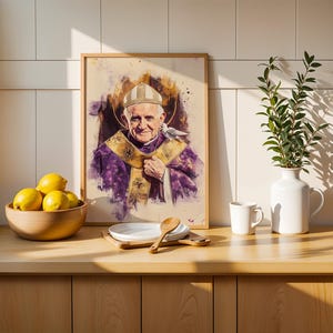 K&ouml;nnte beinhalten: Ein gerahmtes Portr&auml;t im Aquarellstil von Papst Johannes Paul II. in violettem und goldenem Messgewand mit wei&szlig;er Mitra und einer kleinen wei&szlig;en Taube auf der Schulter. Das Kunstwerk steht auf einer Holztheke neben einer Schale mit gelben Zitronen.