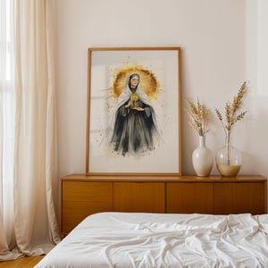 Pode incluir: Uma impress&atilde;o emoldurada em estilo aguarela representando uma figura com h&aacute;bito escuro e v&eacute;u branco segurando um ostens&oacute;rio dourado. A figura est&aacute; centrada contra um halo dourado circular e radiante com efeitos de salpicos de tinta.