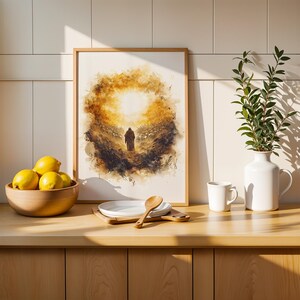 K&ouml;nnte beinhalten: Ein gerahmter Druck im Aquarellstil, der eine einsame Gestalt zeigt, die auf eine helle goldene Sonne zugeht, platziert auf einer Holztheke neben einer Schale mit gelben Zitronen, einem wei&szlig;en Teller mit Holzl&ouml;ffel, einer wei&szlig;en Tasse und einer wei&szlig;en Vase.