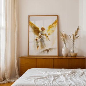May include: A framed wall art print featuring a painting of a large angel with expansive golden wings reaching down to hold the hand of a small child. The angel wears a flowing white robe, and the scene is set against a soft, light background.