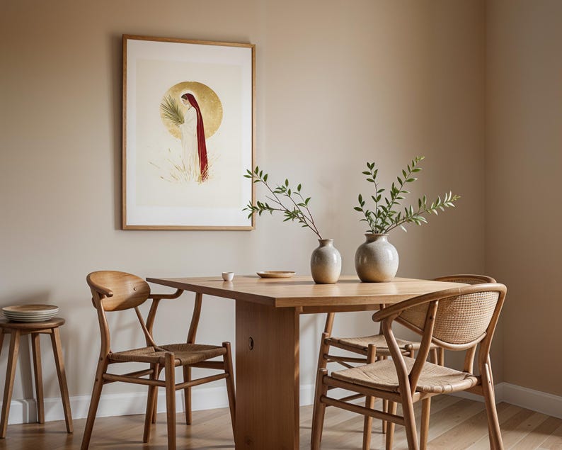 Puede incluir: Una l&aacute;mina de pared enmarcada que representa una figura con t&uacute;nica blanca y capa roja sobre un fondo circular dorado, situada sobre una mesa de comedor de madera con dos jarrones de cer&aacute;mica con ramas verdes y tres sillas de madera.