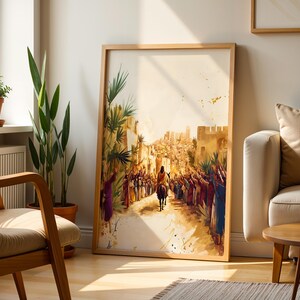 Peut inclure: Une impression d'art encadr&eacute;e repr&eacute;sentant une sc&egrave;ne historique avec une silhouette montant un &acirc;ne &agrave; travers une foule vers une porte de ville. L'&oelig;uvre pr&eacute;sente des tons chauds et att&eacute;nu&eacute;s, des palmes et un fond clair avec des &eacute;claboussures.