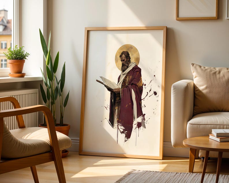 May include: A framed vertical wall art print featuring a bearded figure in a deep maroon robe and white shawl, holding an open book. The figure has a golden circular halo behind the head, set against a cream background with dark paint splatters.