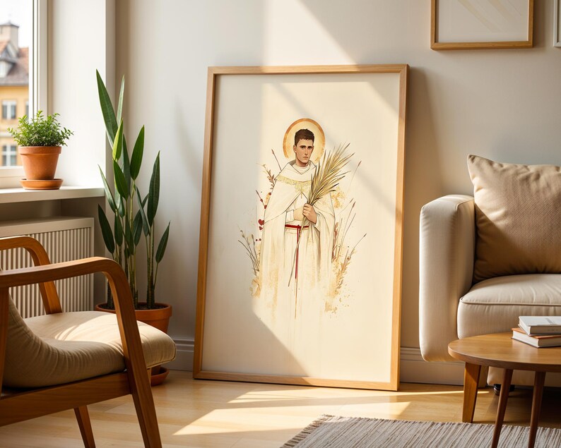 K&ouml;nnte beinhalten: Ein gerahmter vertikaler Wandkunstdruck mit einer Aquarellillustration einer Person in einem wei&szlig;en Gewand mit rotem Kordelg&uuml;rtel, die einen Palmwedel h&auml;lt. Die Figur hat einen goldenen Heiligenschein und ist von stilisierten Weizenhalmen umgeben.