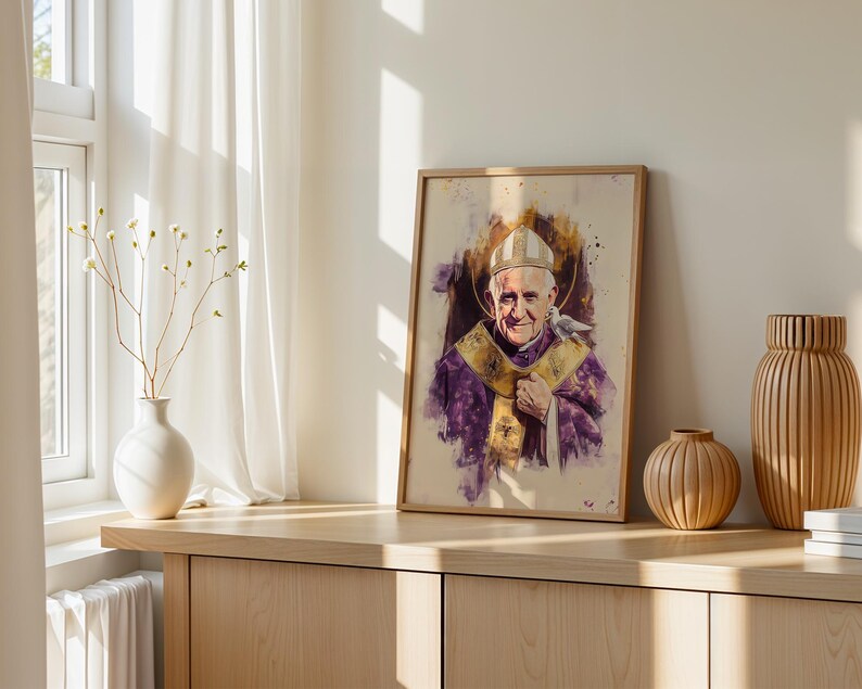 Peut inclure: Un portrait encadr&eacute; style aquarelle du Pape Jean-Paul II portant une mitre blanche et des v&ecirc;tements liturgiques violets avec une &eacute;tole dor&eacute;e. Une petite colombe blanche repose sur son &eacute;paule. L'&oelig;uvre pr&eacute;sente des &eacute;claboussures de peinture violette et dor&eacute;e sur un fond cr&egrave;me.