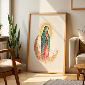 Puede incluir: Una l&aacute;mina de arte mural vertical enmarcada con una ilustraci&oacute;n en acuarela de la Virgen de Guadalupe. Viste un manto color verde azulado con estrellas doradas sobre un vestido rojo, de pie sobre una luna creciente con un halo dorado.