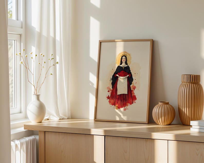 K&ouml;nnte beinhalten: Ein gerahmter Kunstdruck mit der zentralen Illustration einer Figur mit dunklem Haar, goldenem Heiligenschein und Krone, die einen schwarzen Umhang &uuml;ber einem roten Rock tr&auml;gt und eine wei&szlig;e, mit roten Rosen gef&uuml;llte Sch&uuml;rze vor beigem Hintergrund h&auml;lt.