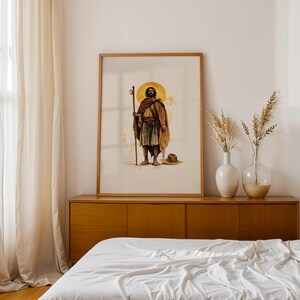 May include: A framed wall art print featuring a watercolour illustration of a bearded figure wearing a brown cloak and tunic, holding a wooden staff. Behind the figure is a large yellow circle. A hat rests on the ground near the figure's feet.
