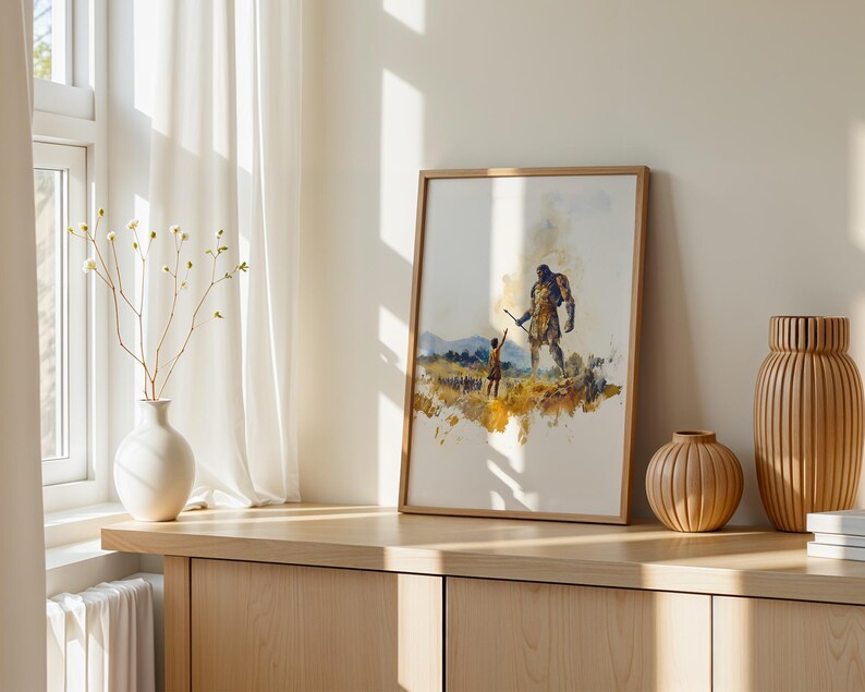May include: A framed watercolour print featuring a small figure reaching towards a large, towering giant in a golden-hued landscape. The artwork uses expressive brushstrokes in shades of yellow, brown, and blue to depict the scene on a white background.