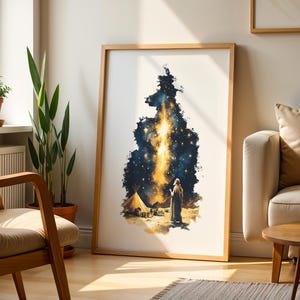 May include: A framed vertical wall art print featuring a dark blue and gold celestial scene. The illustration depicts a figure standing in a desert landscape near a tent, looking up at a bright, glowing vertical beam of light amidst starry skies.