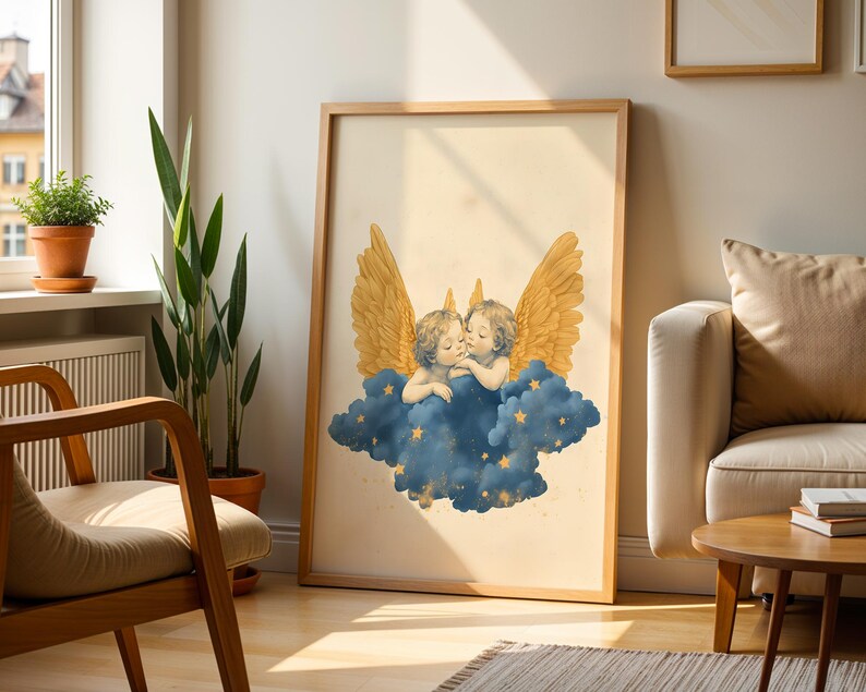 May include: A framed wall art print featuring two cherubs with golden wings resting on a dark blue cloud. The cloud is decorated with small yellow stars, and the background of the print is a light cream colour. The frame is made of light-toned wood.