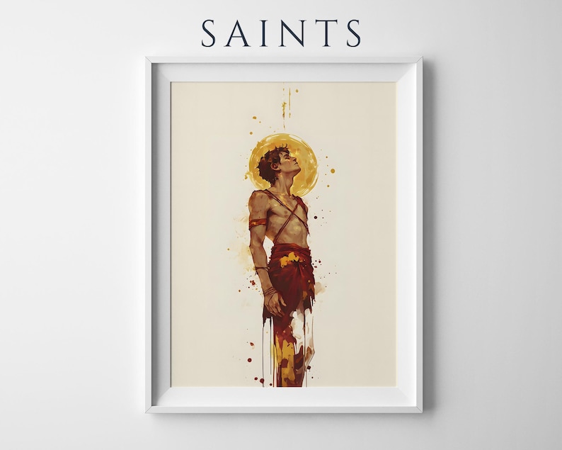 May include: A framed art print titled SAINTS featuring a watercolour-style illustration of a figure with a golden halo looking upward. The figure wears red garments and straps against a cream background with paint splatters in red and yellow tones.