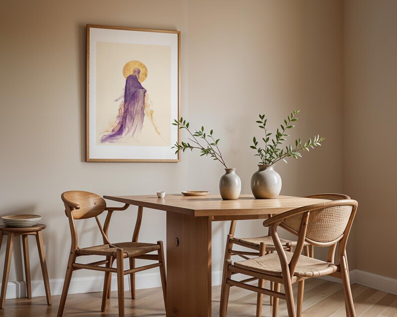 May include: A framed wall art print featuring a figure in a purple robe with a gold halo, displayed above a light wood dining table with two ceramic vases containing green branches, surrounded by three wooden chairs with woven seats.