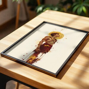 May include: A framed art print featuring a watercolour-style illustration of a person with a golden halo, wearing red and white garments. The figure is depicted in profile against a cream background with red and yellow paint splatters.