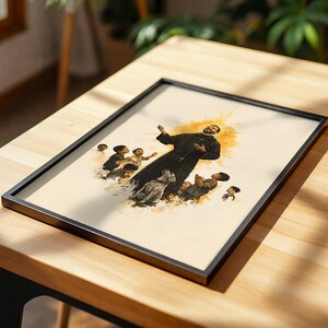 May include: A framed art print featuring a watercolor-style illustration of a figure in a black robe with a cross, surrounded by several children and a dog, set against a soft yellow halo background on a light-colored paper surface.